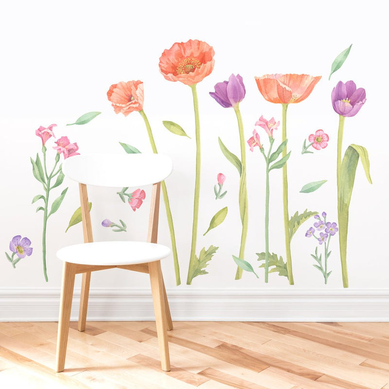 White wooden chair on light hardwood floor in front of watercolor floral wall decals featuring orange poppies and purple tulips