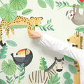 Child pointing at colorful watercolor kids jungle animal wall mural (leopard on branch, toucan, zebra, giraffe, sloth) — nursery and playroom decor wall decal