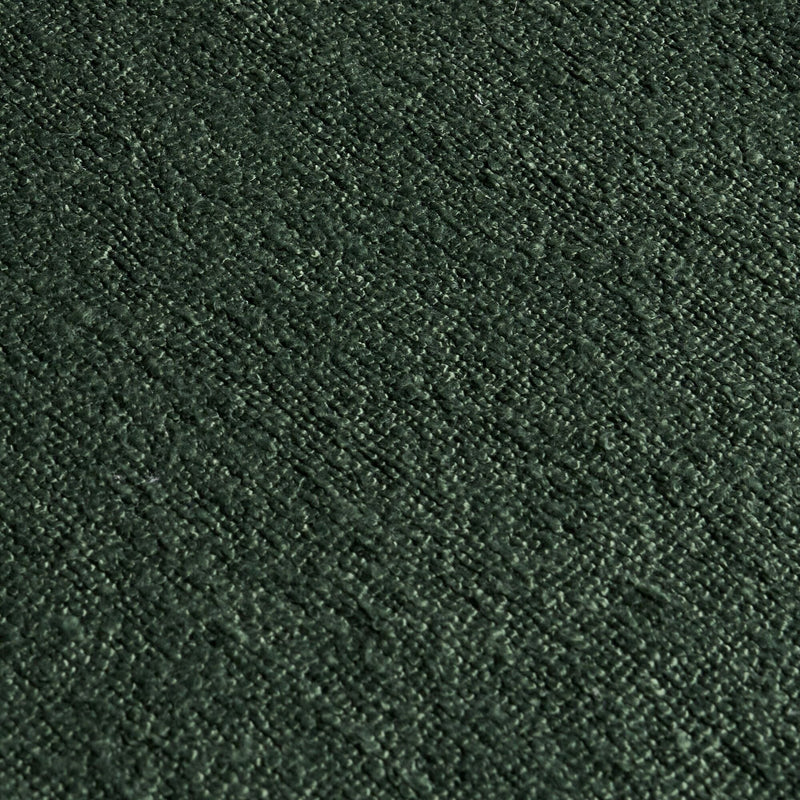 Close-up macro of deep forest green textured upholstery fabric swatch with soft pile and woven pattern