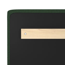 Close-up of green upholstered headboard back showing black fabric backing and a horizontal wooden cleat mounting bracket secured with a screw — furniture hardware detail