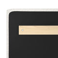 Back of upholstered headboard with black fabric, light wood mounting bracket, metal screw and white linen trim