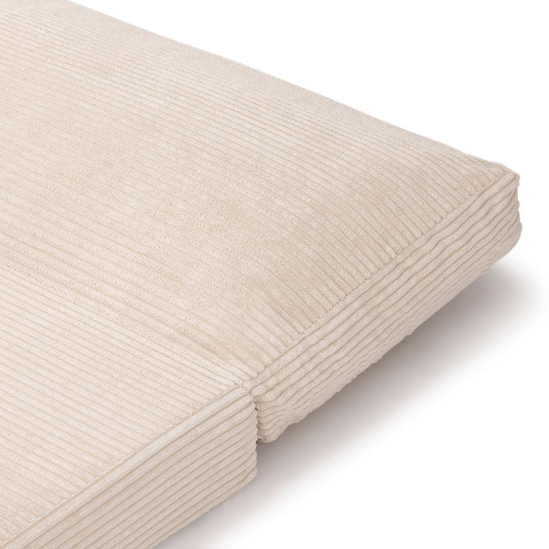 Beige corduroy floor cushion with textured fabric design.