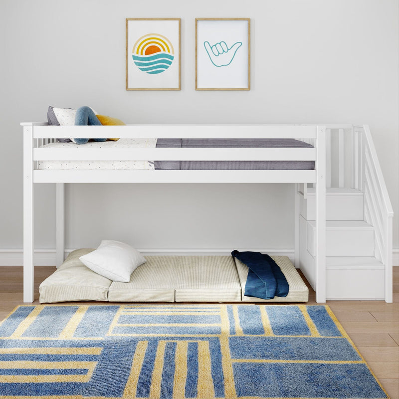 White wooden loft bed with built-in staircase storage above a floor mattress, blue-and-yellow geometric rug, and coastal-themed wall art in a minimalist kids' bedroom