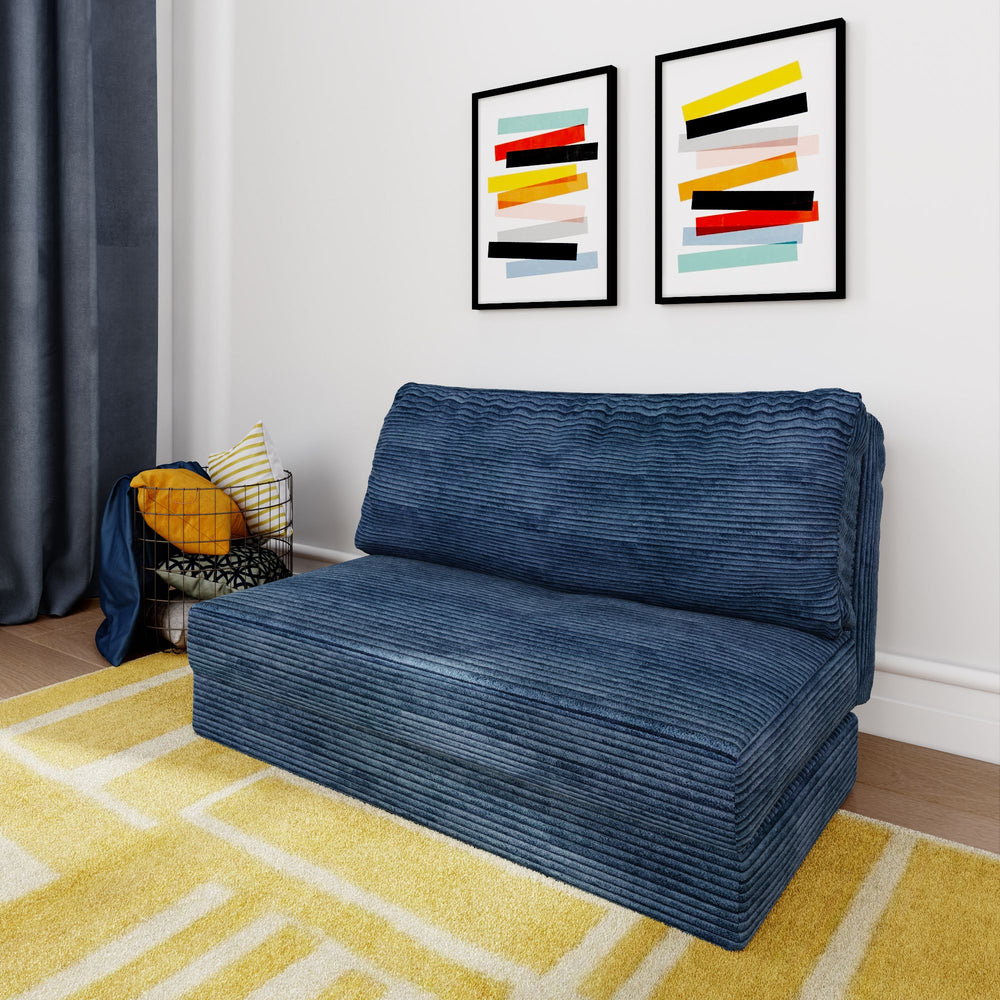 Blue corduroy sofa in modern living room with yellow geometric rug and abstract wall art.