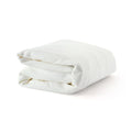 Folded white blanket with textured fabric on white background.