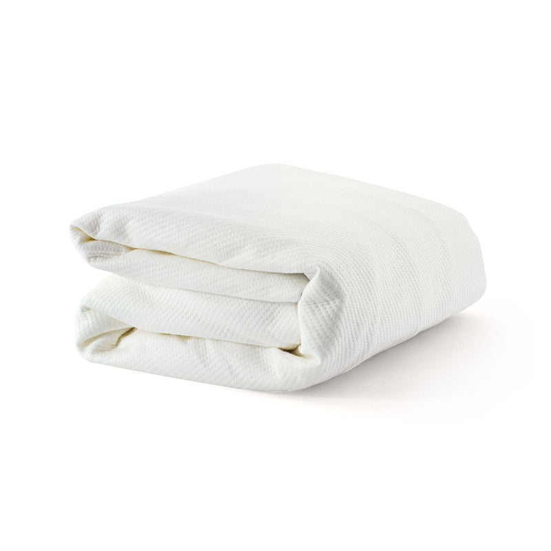 Folded white blanket with textured fabric on white background.