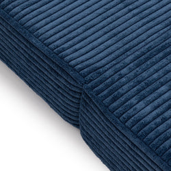 Blue ribbed fabric texture of a modern couch cushion, highlighting detail and quality upholstery.