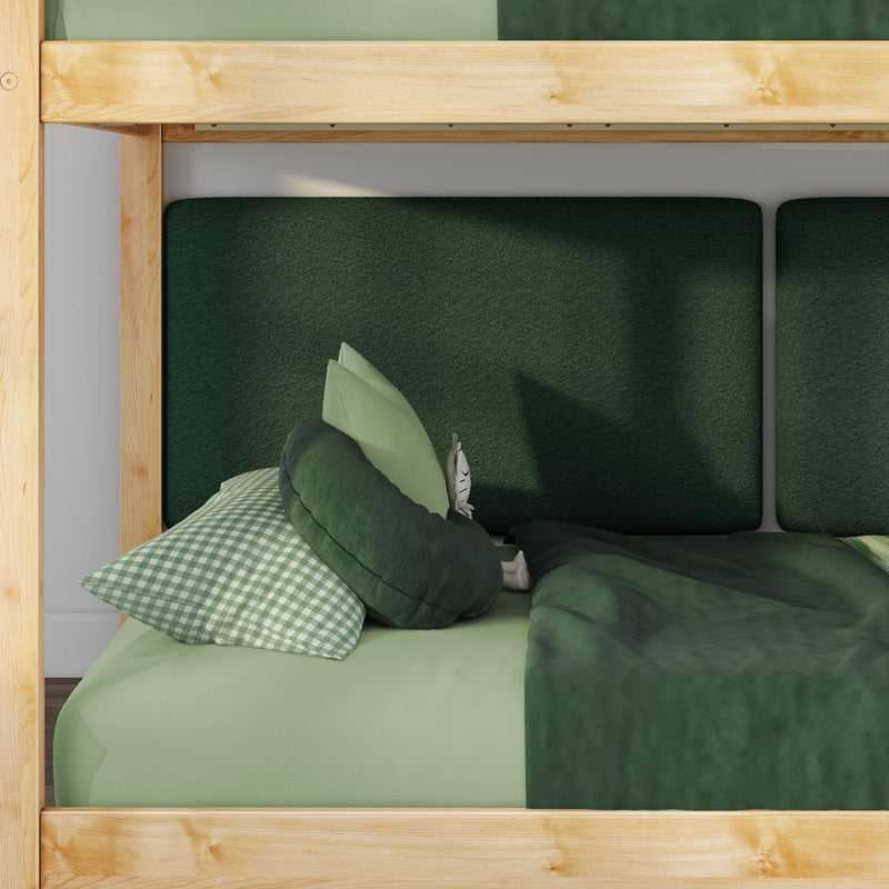Wooden bunk bed with green bedding, dark green upholstered headboard, gingham pillow and round cushion