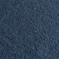 Close-up of dark navy textured bouclé upholstery fabric showing looped pile and woven texture for sofas, cushions, and carpeting