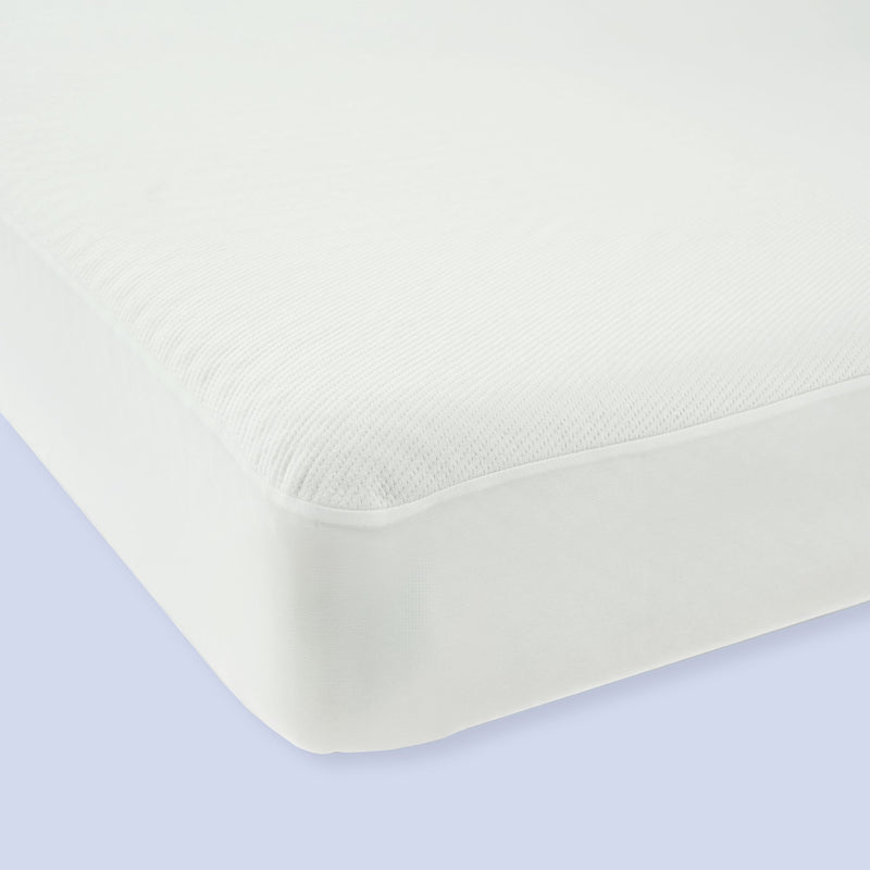 Close-up of a white fitted mattress protector on a bed, showcasing its smooth texture and snug fit for mattress protection.