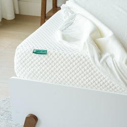 8-inch gel memory foam mattress with white quilted cover and partially removed sheet on modern bed.