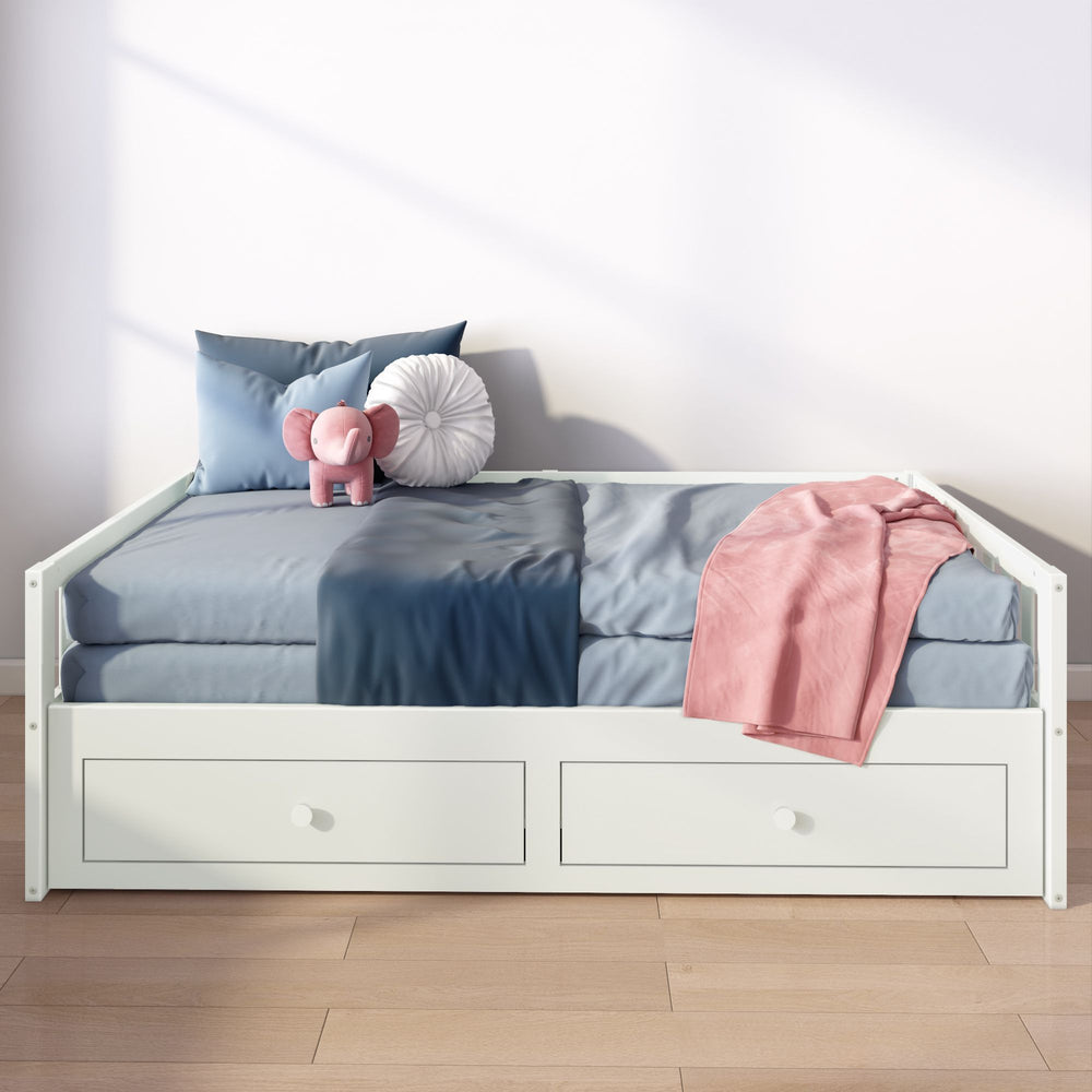 White daybed with blue and pink bedding, including plush elephant toy and underbed storage drawers.