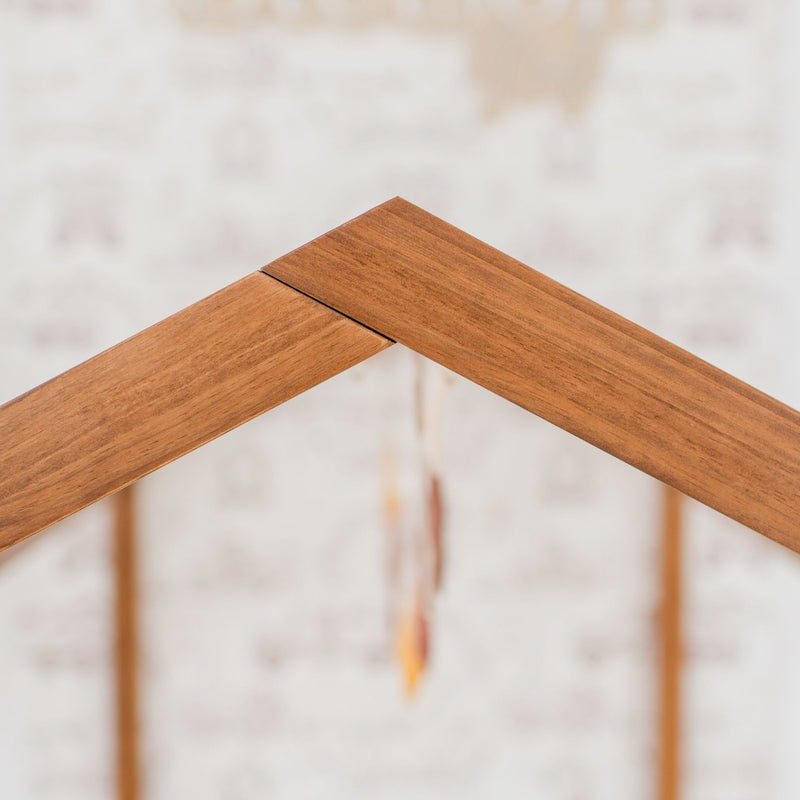 Close-up of interlocking natural wood rafters forming a roof peak on a residential construction site