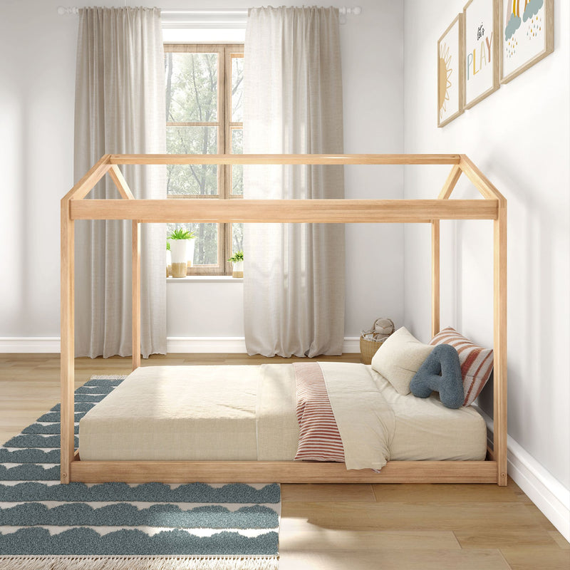 Minimal natural wooden house-frame bed in bright neutral children's bedroom with beige curtains striped pillow blue cloud rug and framed play wall art
