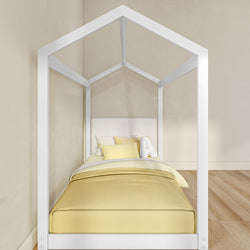 Modern white house-shaped kids bed frame with yellow bedding and pillows in a minimalist nursery on hardwood floors