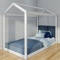 White wooden house-frame twin bed with blue bedding and pillows in a modern kids' bedroom on hardwood floor