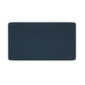 Close-up of navy blue textured bath mat with rounded corners on a white background
