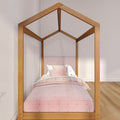 Single wooden house-frame canopy bed with natural oak finish and soft pink bedding in a minimalist children's bedroom