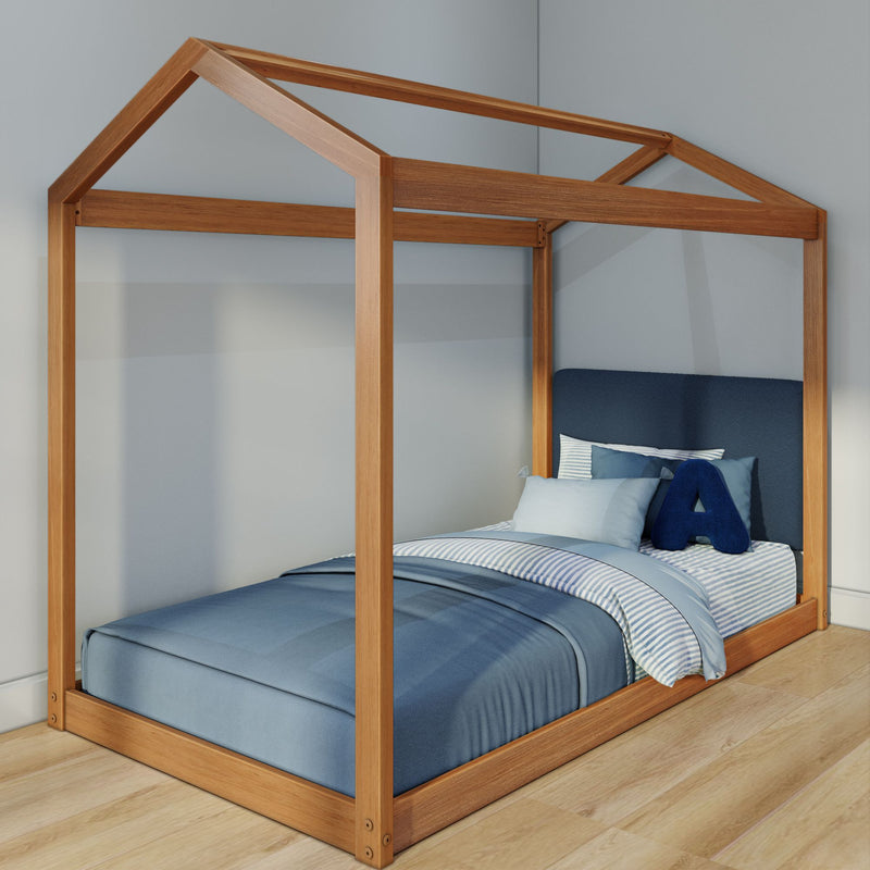 Wooden house-frame kids bed with natural oak finish, blue bedding and striped pillow in a minimalist bedroom with light wood floor