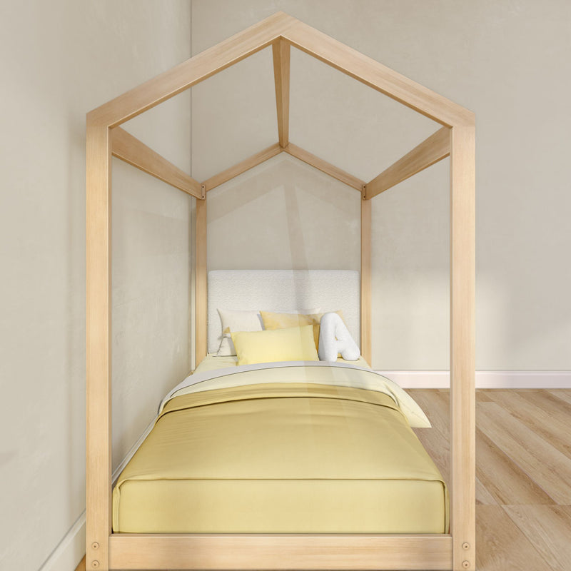 Minimalist wooden house-frame canopy kids bed with yellow bedding and upholstered headboard in a neutral modern children's bedroom