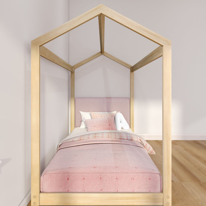 Modern wooden house-frame kids' bed with pink upholstered headboard and pastel bedding in a minimalist children's bedroom with hardwood floor