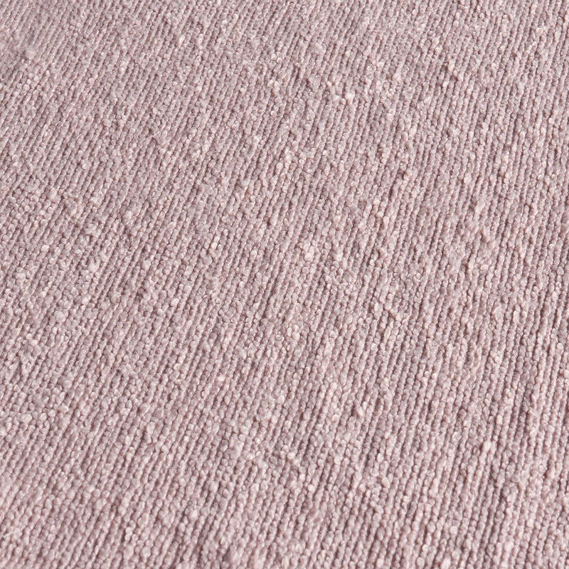 Close-up of blush pink boucle fabric texture with looped yarn and ribbed pattern for upholstery, rugs, and home decor