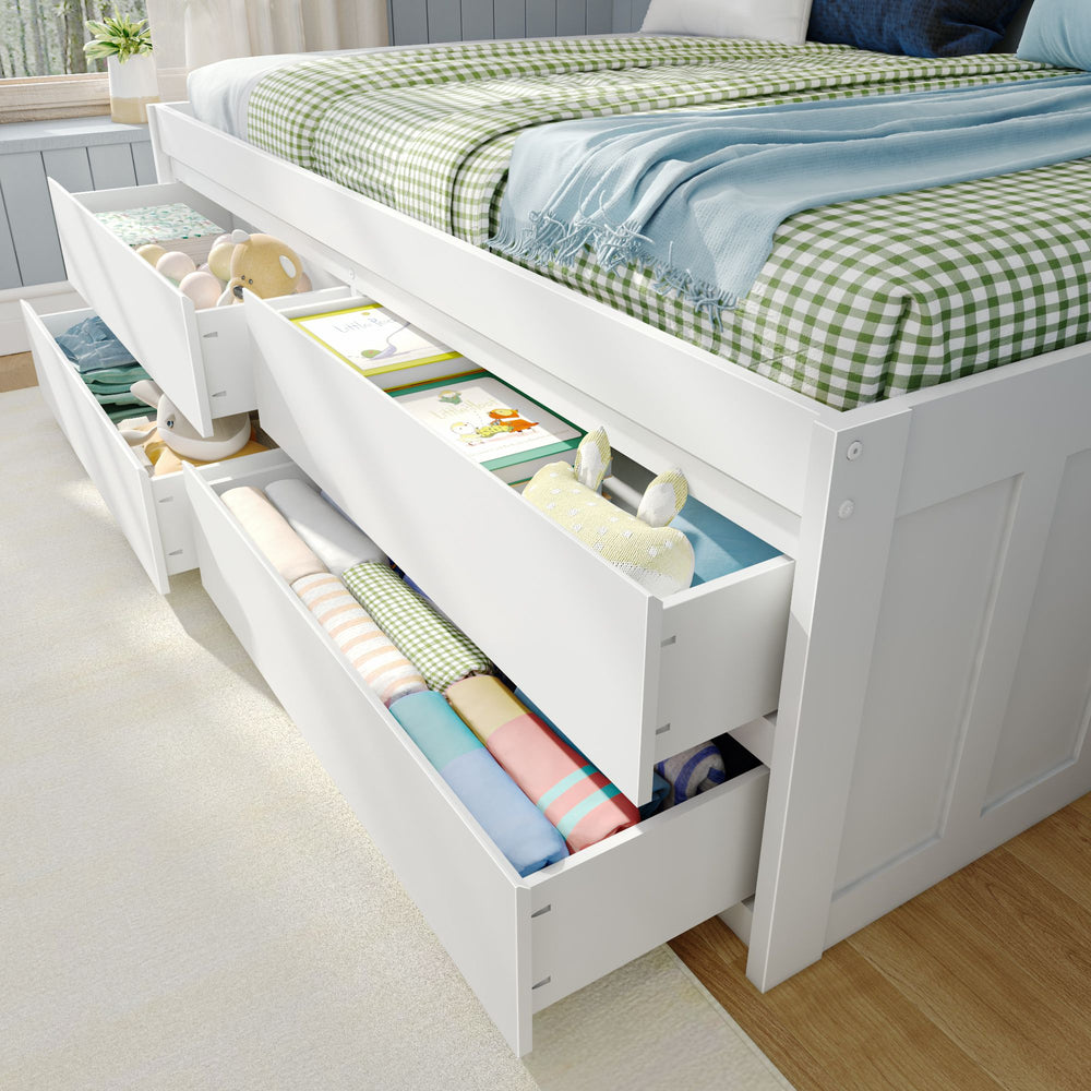 White storage bed with built-in drawers filled with organized clothes and toys in a bright bedroom.
