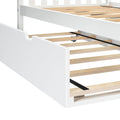 White wooden bed frame with slatted wooden base and pull-out underbed storage trundle on caster wheels