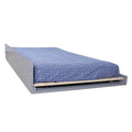 Gray pull-out trundle bed with blue patterned mattress on wooden slats, a space-saving under-bed guest bed for small bedrooms