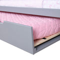 Gray wooden trundle bed with pink quilted mattress and plywood slats — space-saving children's bedroom furniture