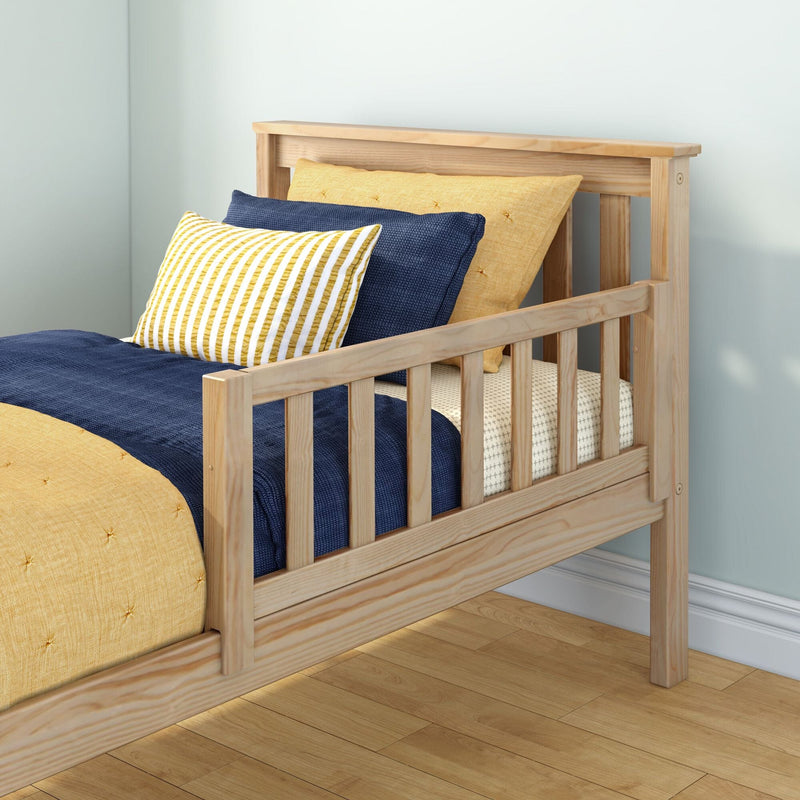 Natural pine twin bed frame with navy duvet and yellow striped accent pillow on light hardwood floor against pale blue wall