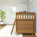 Nursery loft bed with built-in dresser and wooden frame in coastal-themed kids room with blue wave wallpaper, window, potted plant and framed art