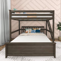 Dark wood twin-over-twin bunk bed with ladder, white bedding and colorful throw pillows in a modern kids bedroom with pink geometric accent wall and potted plant
