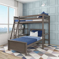 Modern gray wooden loft bunk bed with ladder and blue bedding in a light-blue paneled kids' bedroom by large window — space-saving twin-over-twin design