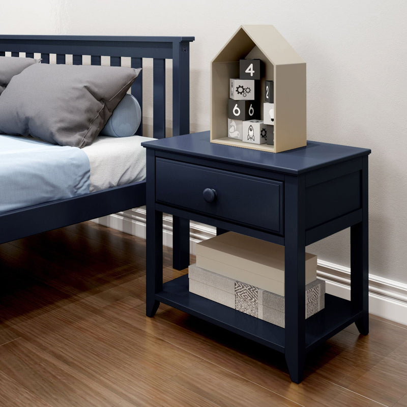 Blue wooden nightstand with drawer and shelf, next to a modern bed, featuring decorative blocks and a storage box, on a wooden floor.