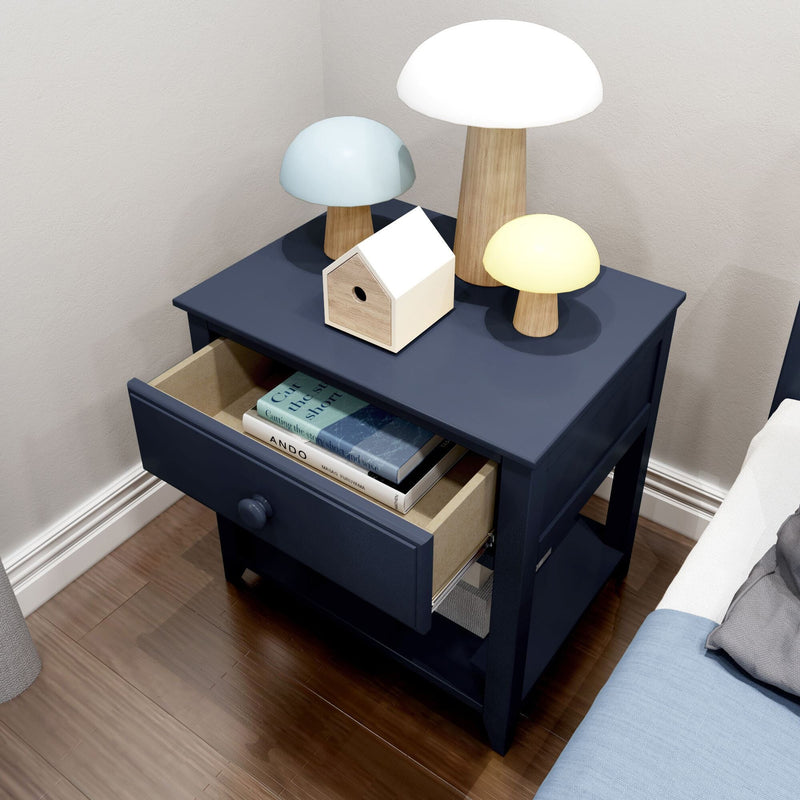 Navy blue nightstand with open drawer displaying books and decorative wooden lamps, modern bedroom furniture.