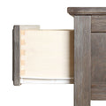 Close-up of an open rustic gray wood dresser drawer showing dovetail joints, white interior, and metal drawer glides
