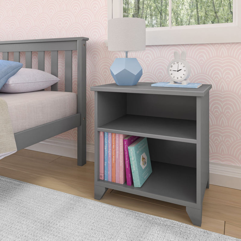 Gray kids' bedroom nightstand with books, modern lamp, and clock.