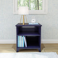 Navy blue wooden nightstand with books, table lamp, and a clock in a modern bedroom setting.