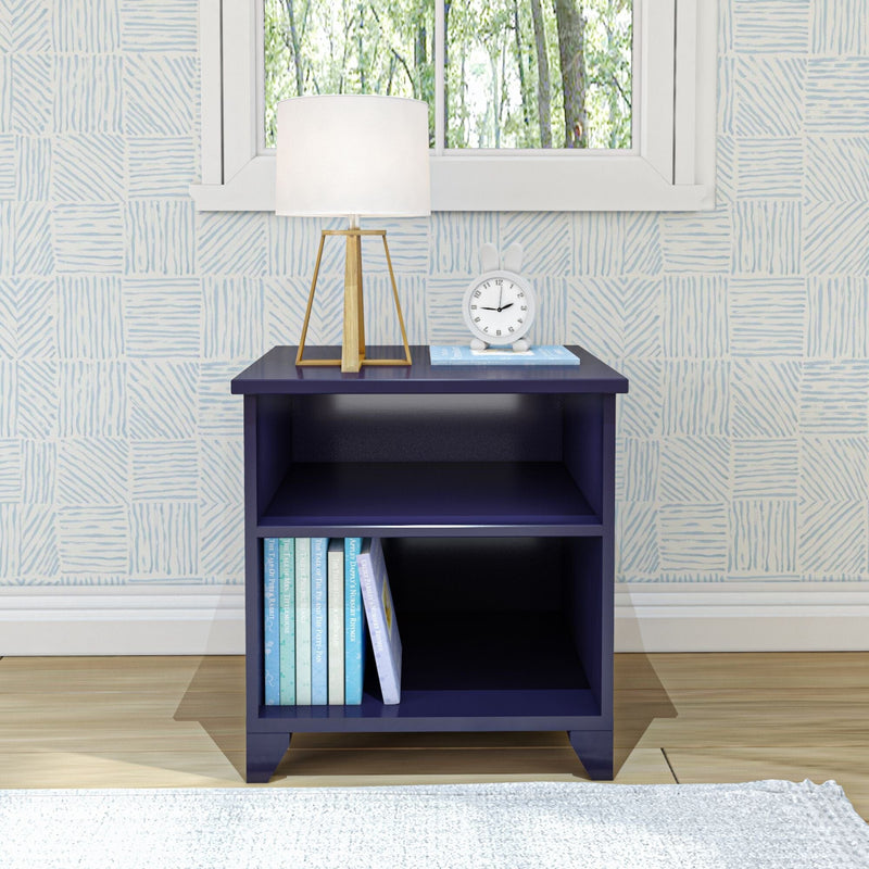 Navy blue wooden nightstand with books, table lamp, and a clock in a modern bedroom setting.