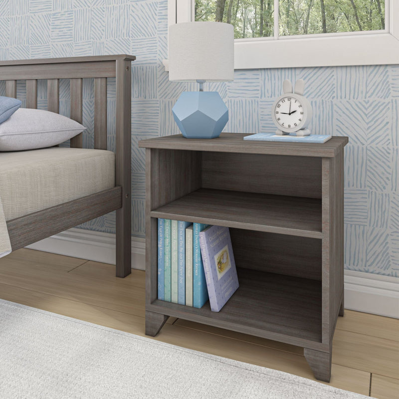 Gray wooden nightstand with decorative blue table lamp and books in a modern bedroom setting.