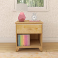 Wooden nightstand with a pink geometric lamp, bunny-shaped clock, and colorful books, in a cozy bedroom setting.