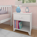 White nightstand with books, a blue geometric lamp, and a bunny clock in a child's pink-themed bedroom.