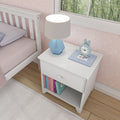 White nightstand with books and a blue clock in a cozy bedroom setting.