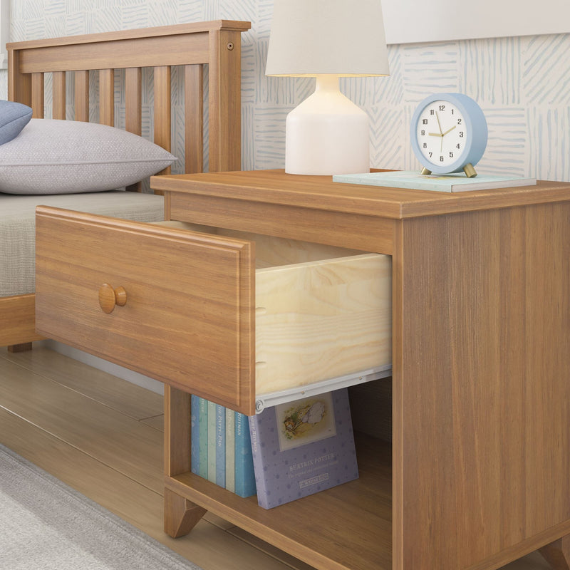 Wooden nightstand with open drawer, table lamp, clock, and books in a cozy bedroom setting.