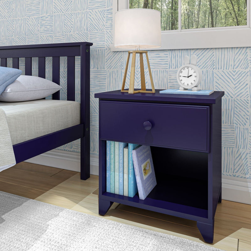 Blue wooden nightstand with a modern lamp, clock, and books in a stylish bedroom setting with patterned wallpaper and a large window.
