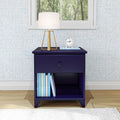 Vintage-style navy blue nightstand with a drawer, featuring a white table lamp and books, set against a patterned wall in a cozy bedroom.