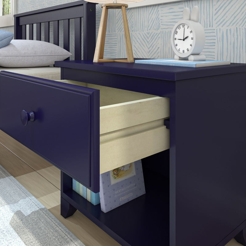 Navy blue wooden nightstand with open drawer and shelf featuring books and an alarm clock in a modern bedroom.