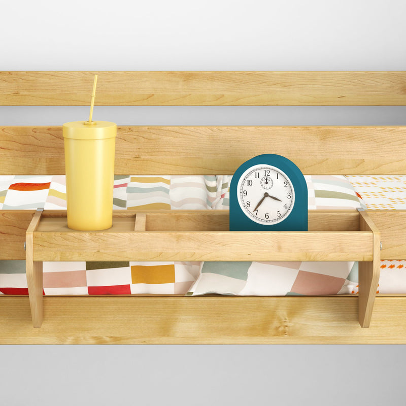 Wooden bed shelf with a yellow cup and alarm clock, colorful bedspread background.