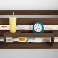 Wooden headboard shelf holding a yellow straw tumbler and blue alarm clock over colorful geometric-patterned bedding in a modern bedroom